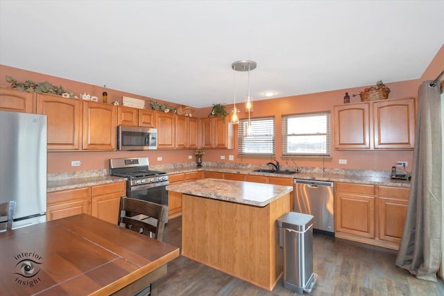 kitchen with a sink, a kitchen island, pendant lighting, stainless steel appliances, and dark wood-style flooring