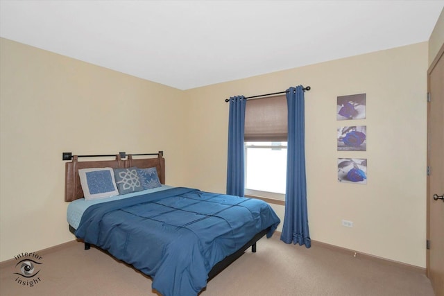 bedroom featuring light colored carpet and baseboards