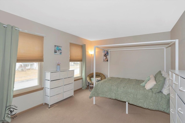 bedroom with baseboards and light colored carpet