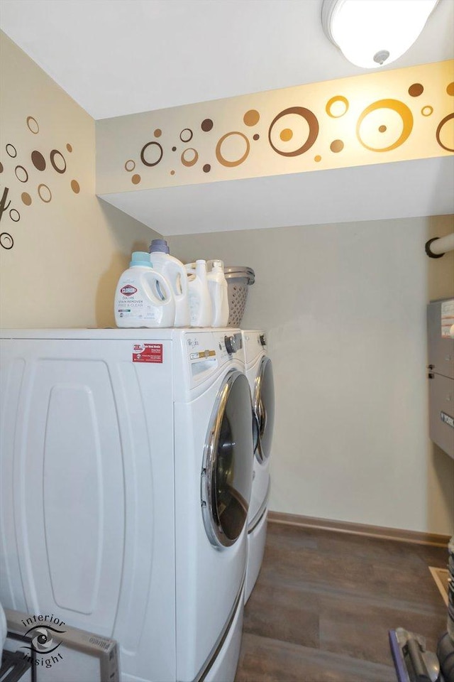 clothes washing area featuring washer and dryer, baseboards, wood finished floors, and laundry area