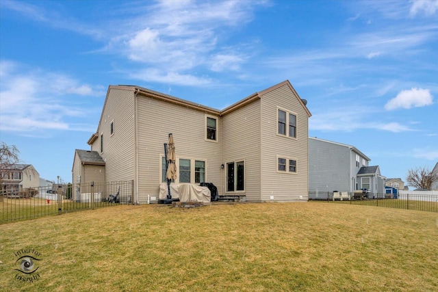 back of house with a fenced backyard and a yard