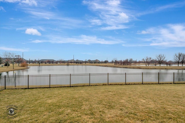 view of yard with a fenced backyard and a water view