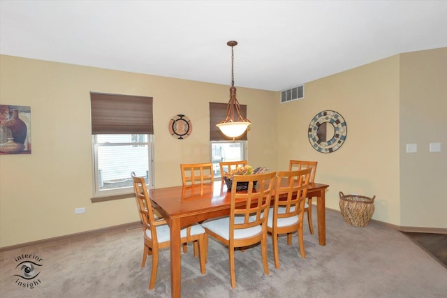 dining room with visible vents, light colored carpet, and baseboards