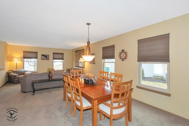 dining area featuring light colored carpet and baseboards