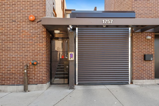 doorway to property featuring brick siding and a gate