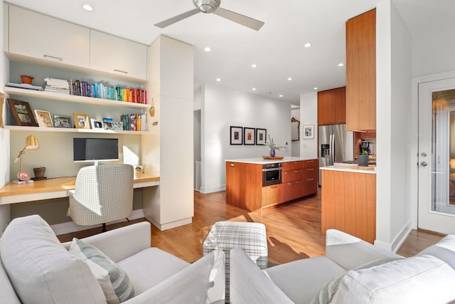 office with ceiling fan, recessed lighting, built in desk, and light wood-type flooring