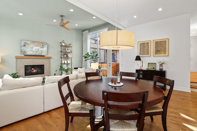 dining area featuring recessed lighting, a glass covered fireplace, light wood-style flooring, and a ceiling fan