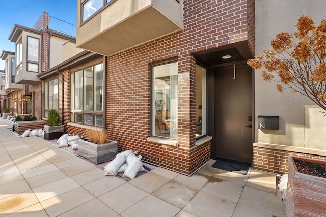 entrance to property featuring brick siding