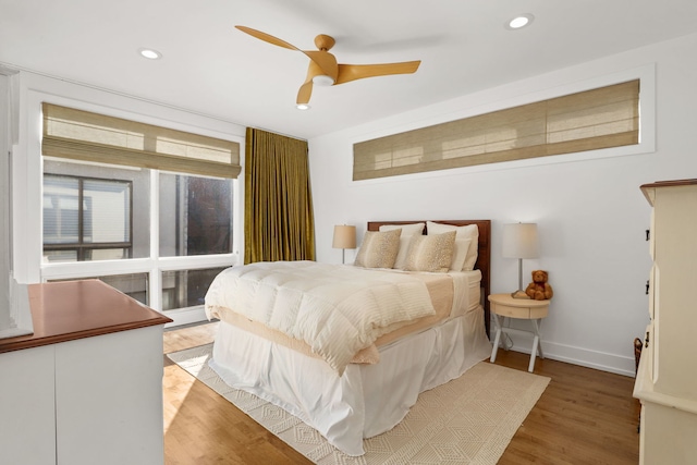 bedroom with a ceiling fan, recessed lighting, wood finished floors, and baseboards