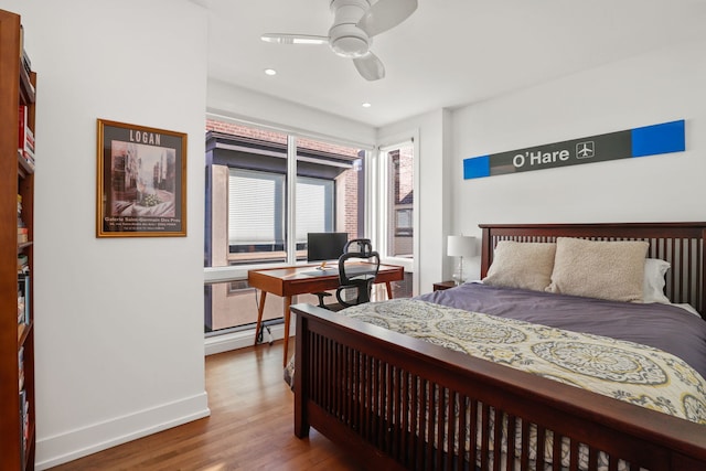 bedroom featuring a ceiling fan, wood finished floors, baseboards, a baseboard radiator, and recessed lighting