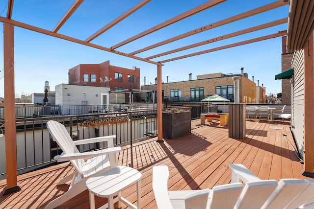 wooden terrace featuring a water view and a pergola