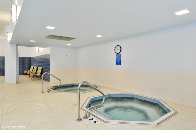 view of swimming pool with an indoor hot tub