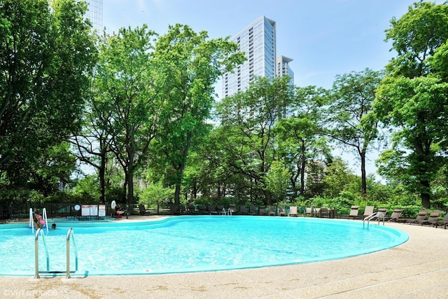 view of swimming pool featuring a patio and fence