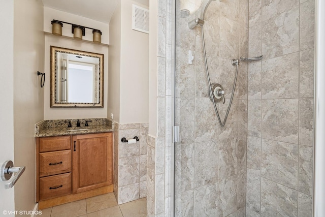 bathroom with tile patterned floors, visible vents, vanity, and a shower stall