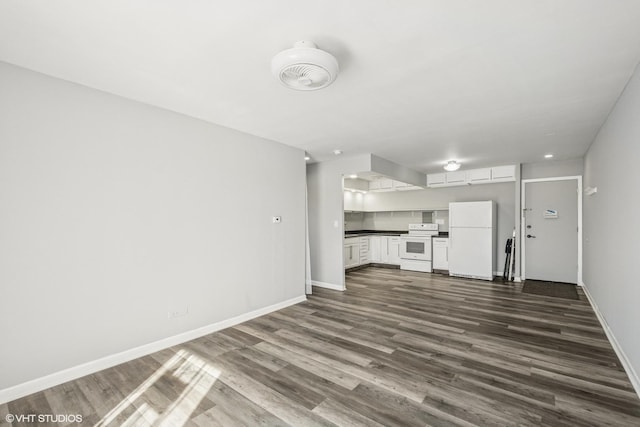 unfurnished living room featuring baseboards and dark wood-type flooring