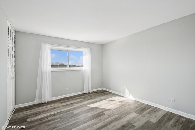 empty room featuring baseboards and wood finished floors