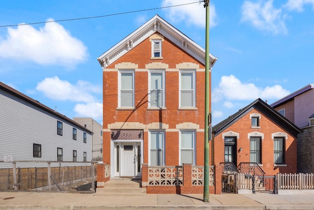 view of front of property with a fenced front yard and brick siding