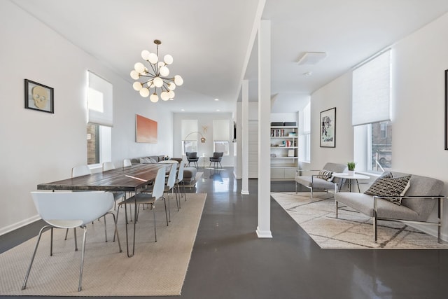 dining area with a notable chandelier, baseboards, a wealth of natural light, and finished concrete floors