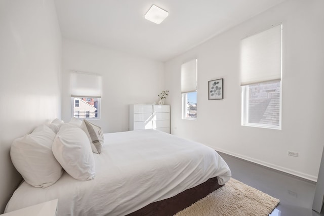 bedroom featuring baseboards and multiple windows