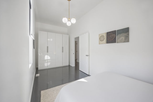 bedroom with wood finished floors and a chandelier