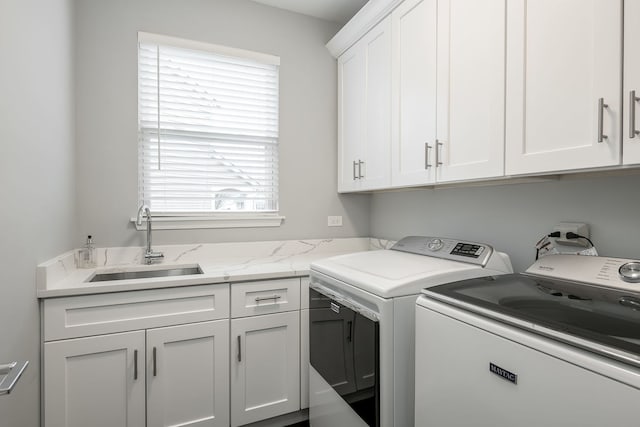 clothes washing area with cabinet space, washing machine and dryer, and a sink