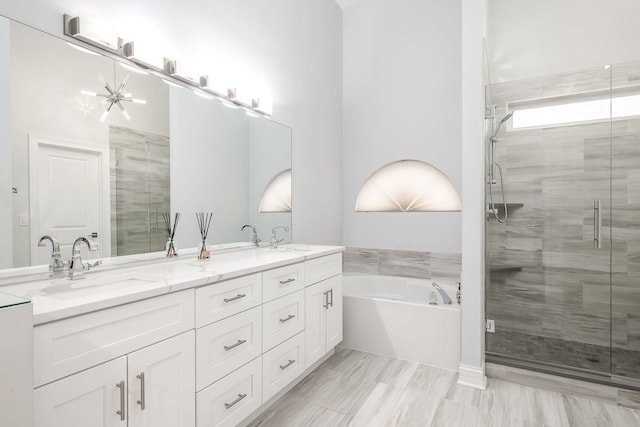 full bathroom featuring a bath, a sink, a shower stall, and double vanity