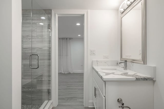 bathroom featuring recessed lighting, a shower stall, vanity, and wood finished floors