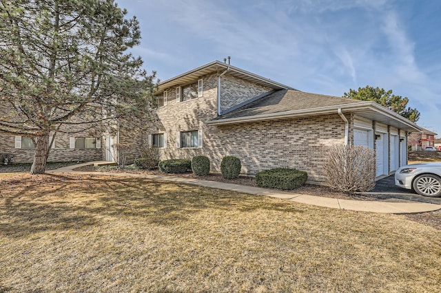 view of home's exterior featuring brick siding, an attached garage, and a yard