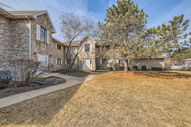 exterior space with a front yard and brick siding