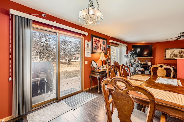 dining area with ceiling fan with notable chandelier, wood finished floors, visible vents, and baseboards