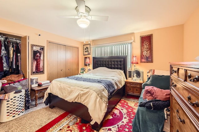 bedroom featuring a ceiling fan, light colored carpet, and two closets