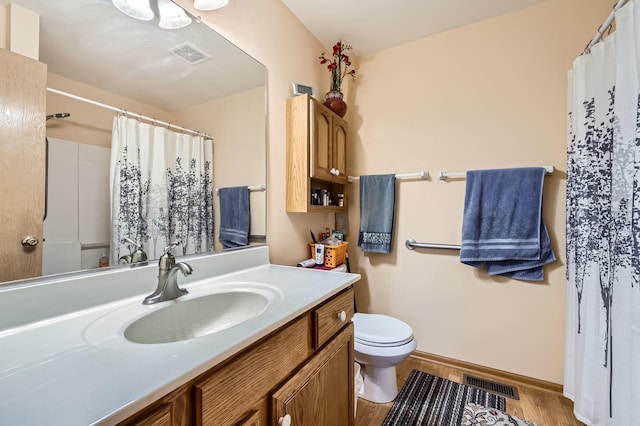 full bathroom featuring visible vents, toilet, wood finished floors, and vanity