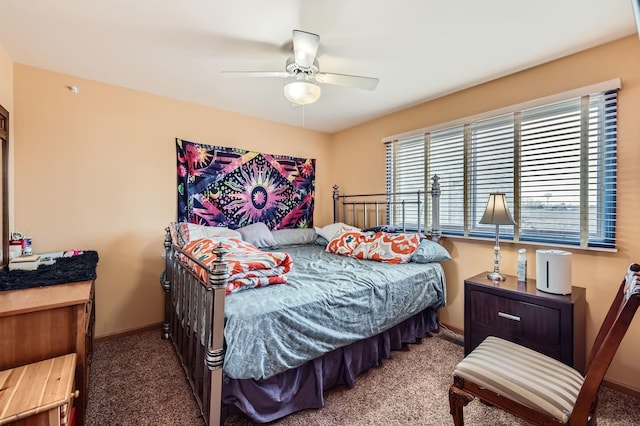 carpeted bedroom with ceiling fan and baseboards