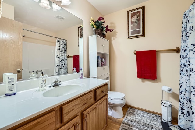 full bathroom with vanity, a shower with curtain, wood finished floors, visible vents, and toilet