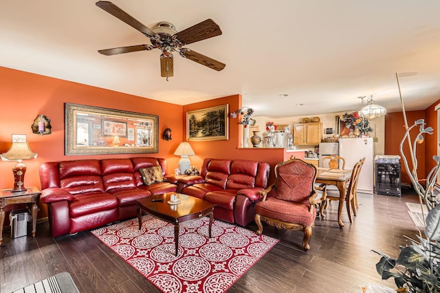 living room featuring ceiling fan with notable chandelier and wood finished floors