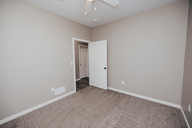 spare room featuring baseboards, carpet floors, visible vents, and ceiling fan