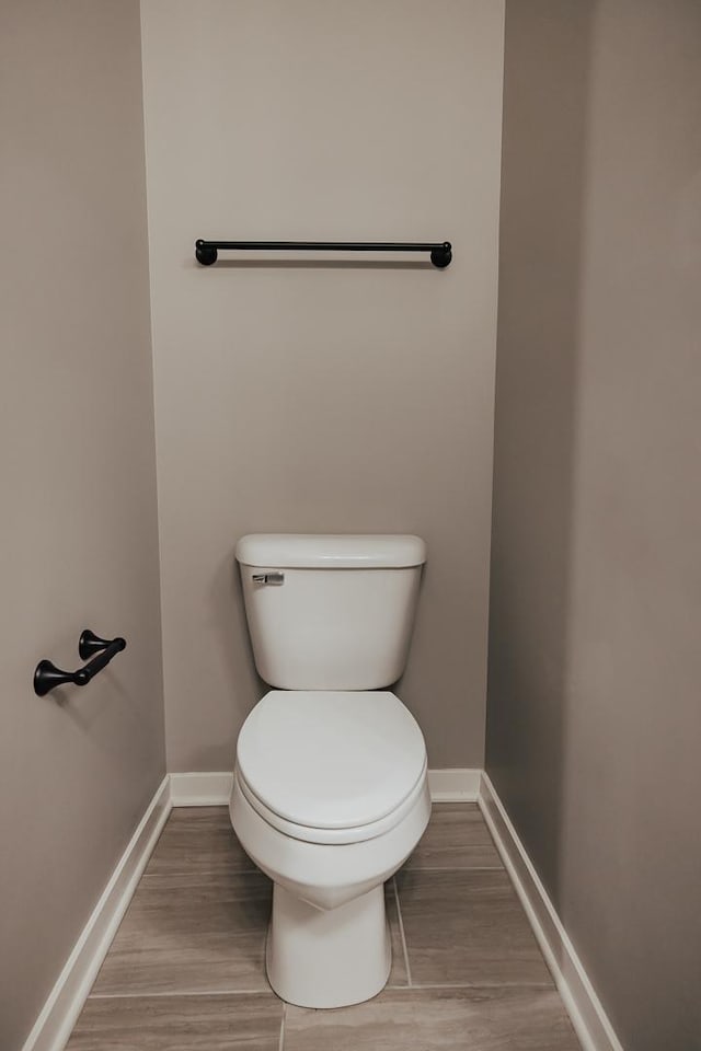 bathroom featuring toilet, baseboards, and wood finished floors