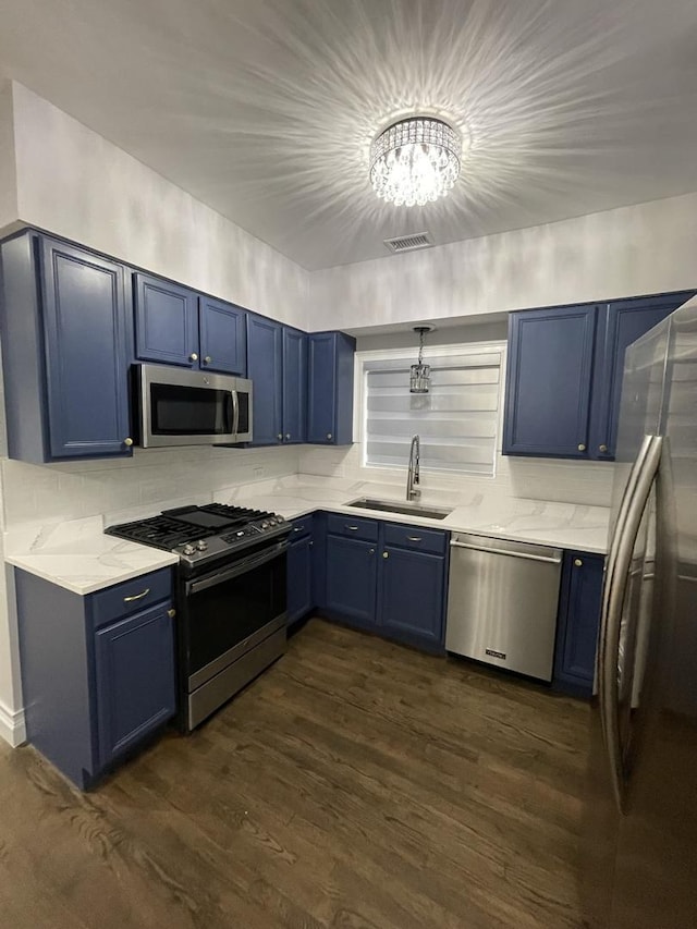 kitchen featuring blue cabinets, visible vents, a sink, stainless steel appliances, and dark wood-style flooring