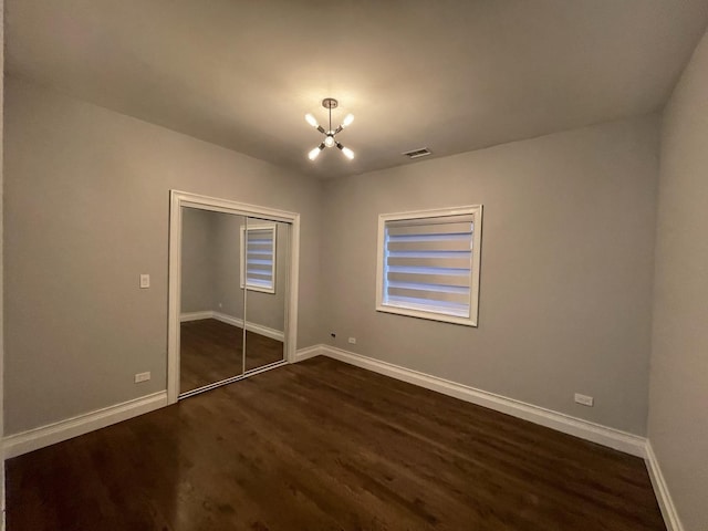 unfurnished bedroom featuring an inviting chandelier, baseboards, and visible vents