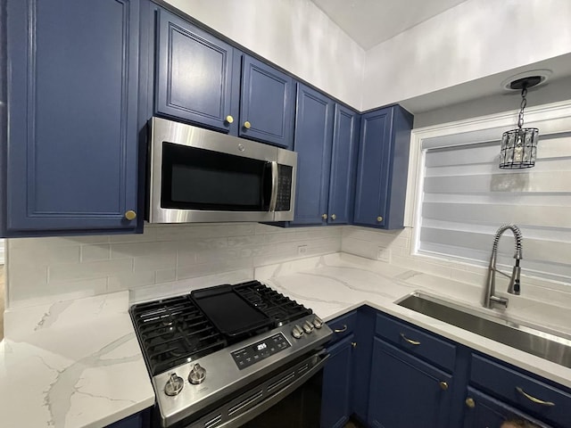 kitchen with light stone counters, blue cabinetry, a sink, appliances with stainless steel finishes, and tasteful backsplash