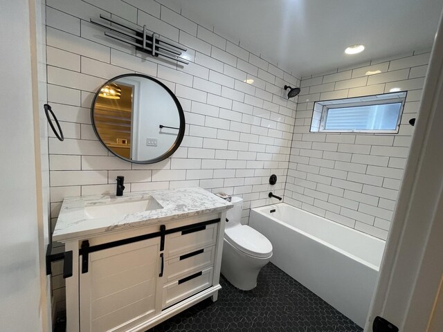 full bathroom with toilet, vanity, tile walls, tile patterned flooring, and shower / bathtub combination