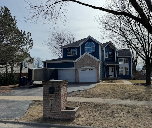 view of front of home featuring brick siding, a garage, and driveway