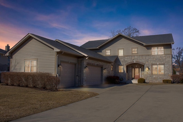 traditional-style home featuring stone siding, concrete driveway, and a garage