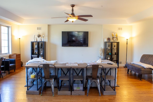 dining room with a ceiling fan, wood finished floors, and visible vents