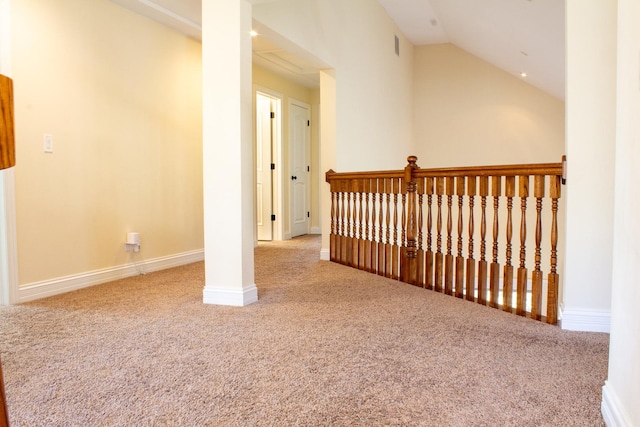 hallway featuring baseboards, lofted ceiling, carpet, and visible vents