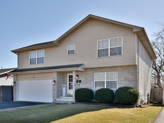 view of front of home featuring driveway, fence, a front yard, an attached garage, and brick siding