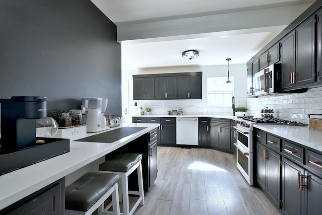 kitchen featuring decorative backsplash, white appliances, decorative light fixtures, and light wood-type flooring