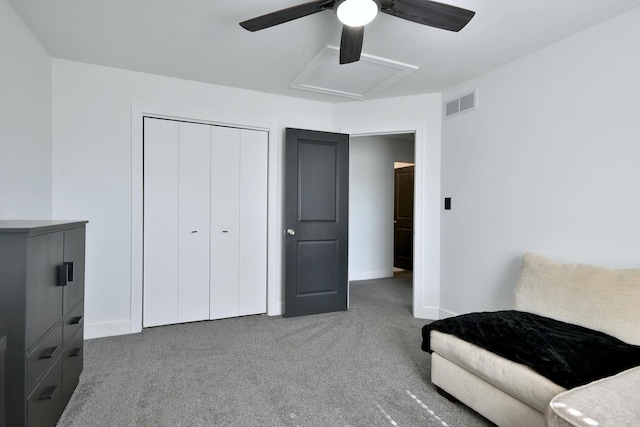 carpeted bedroom featuring a ceiling fan, baseboards, visible vents, attic access, and a closet