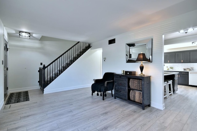 interior space featuring baseboards, light wood-style floors, and stairs