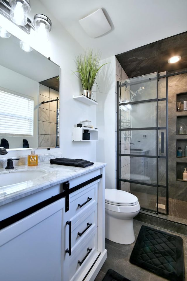 full bath with a shower stall, vanity, and toilet